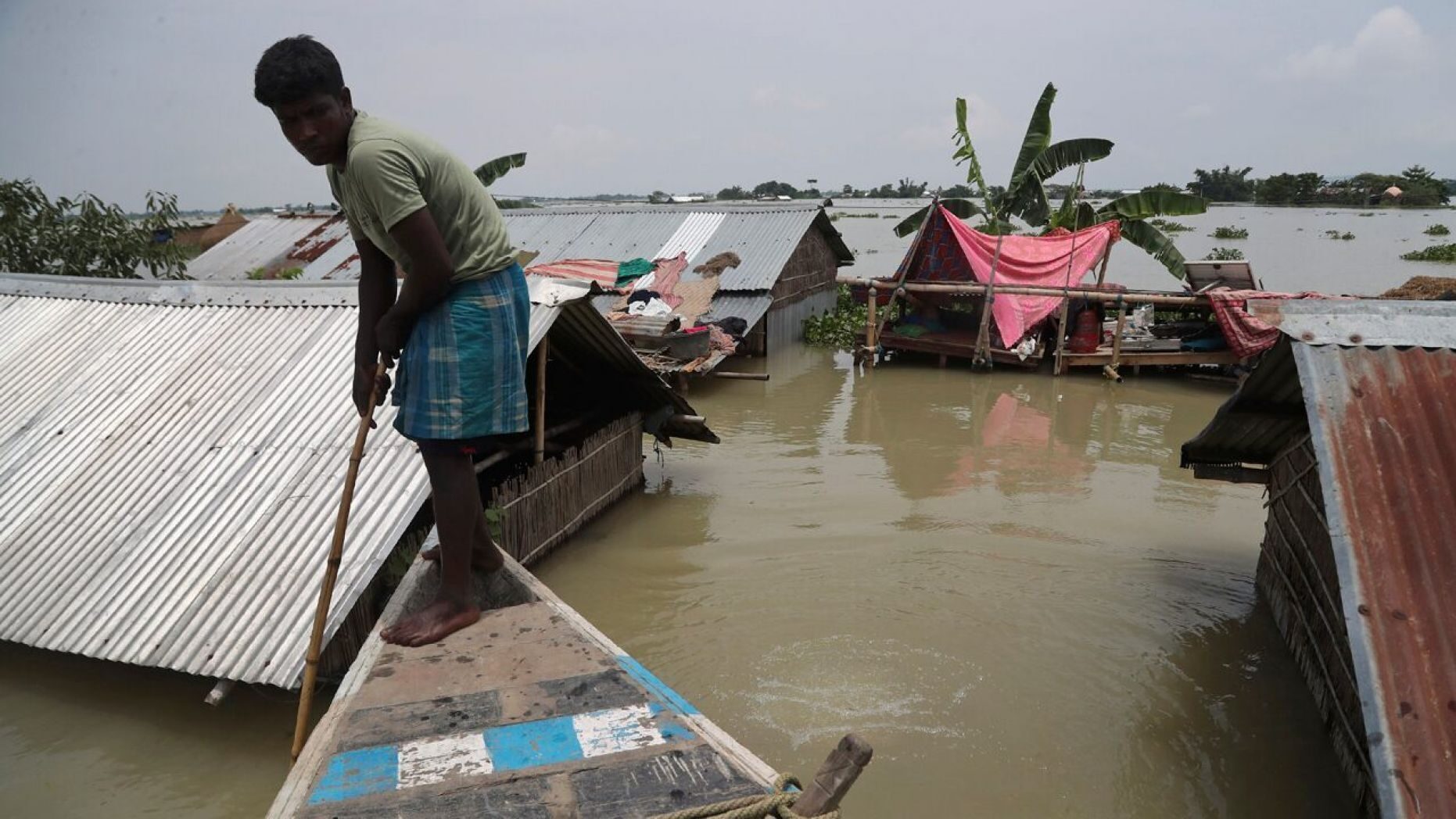 A man rows a boat near his submerged house in Gagolmari village, in Morigaon district of Assam, India, July 14.