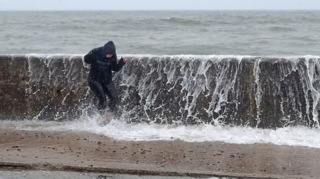 A person is hit by a wave crashing on the Front Strand in Youghal, County Cork