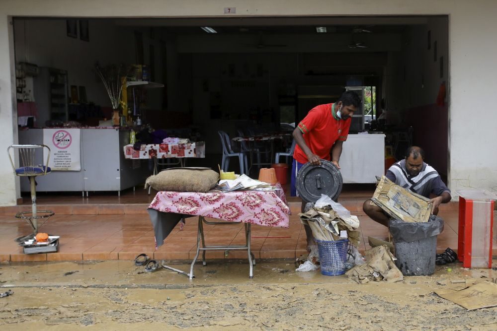 Click to enlarge Restaurant workers are seen salvaging items after Seremban was hit by flash floods earlier today.