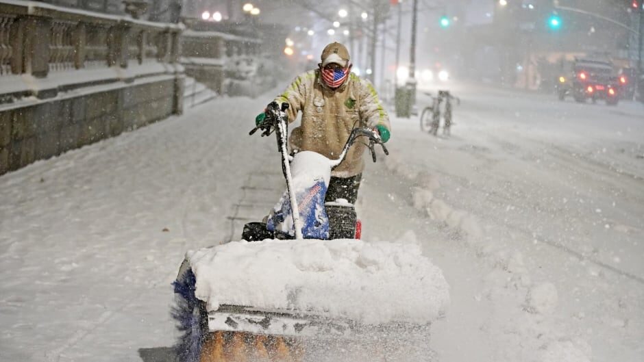 A man clears snow as snow falls near Bryant park in Manhattan, New York City Wednesday.