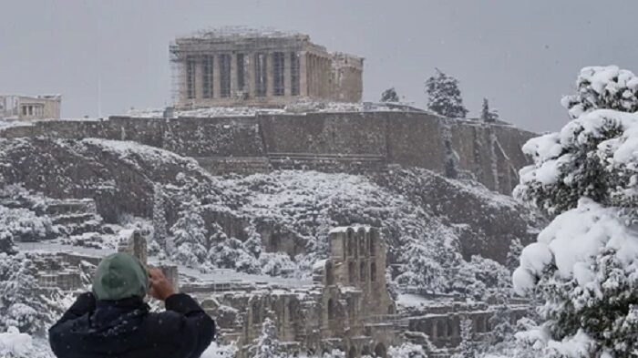 The Parthenon temple on the Acropolis hill archaeological site during a heavy snowfall in Athens