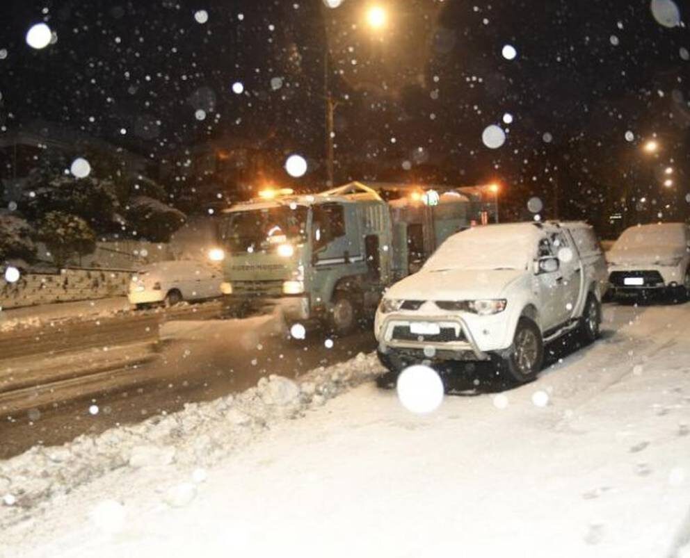 A Fulton Hogan truck ploughs snow in Taieri Rd this morning.