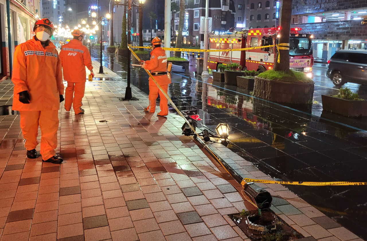 Firefighters respond to a downed streetlight in Jeju, South Korea, on Thursday, in this photo provided by the Jeju Fire Safety Headquarters.