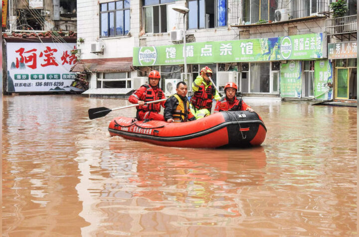 Rescuers evacuating residents in a flooded area after heavy