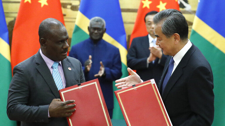 Chinese State Councillor and Foreign Minister Wang Yi (R) and Solomon Islands