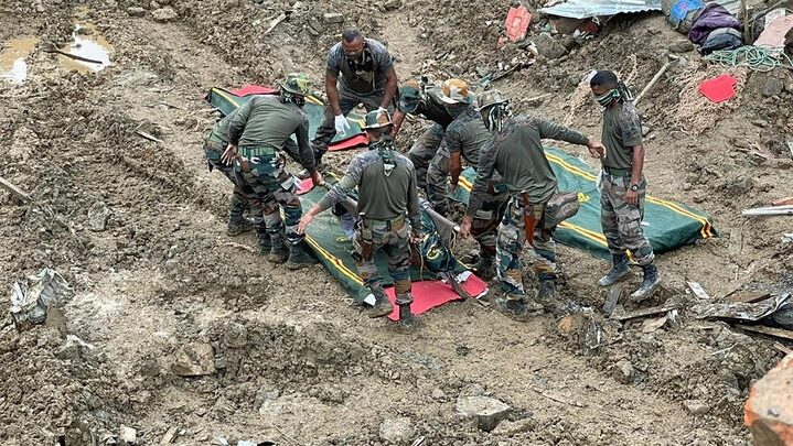 Soldiers carry the body of a victim during rescue efforts after the landslide