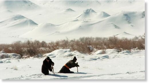Men use sticks to wade through deep snow in rural Khovd province in far-western Mongolia. (file)