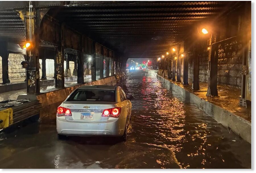 Click to enlarge A car passes through a flooded viaduct Thursday night on Western Avenue under the Metra tracks just south of Grand Avenue.