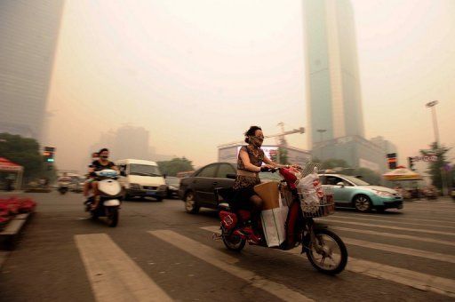 Chinese motorists in Wuhan wear masks