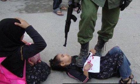 Click to enlarge IDF steps on child, gun at her head