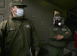 Police wear masks to protect them from ash, in Chaiten,