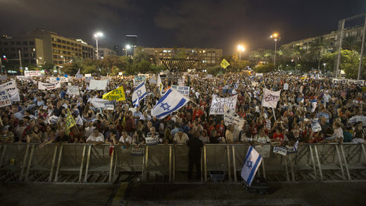 People hold signs during a rally in Tel Aviv