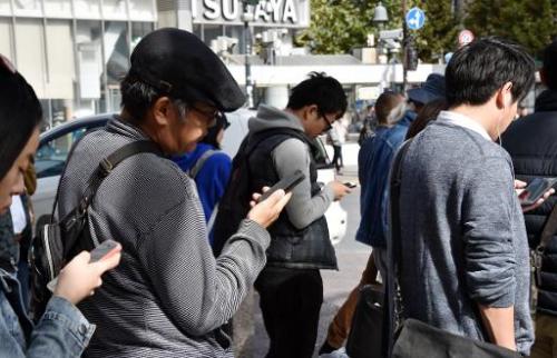 Click to enlarge Pedestrians use their smartphones