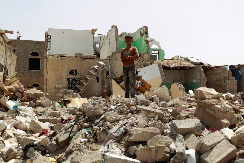 Yemeni boy stands amidst rubble