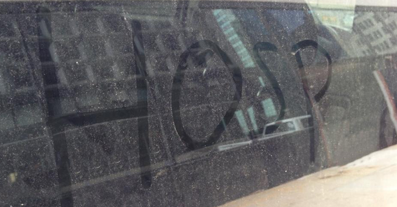 HOSP written on dirty patrol car window