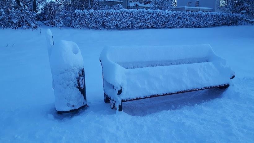 Snow on bench in park