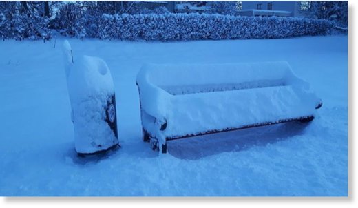 Snow on bench in park