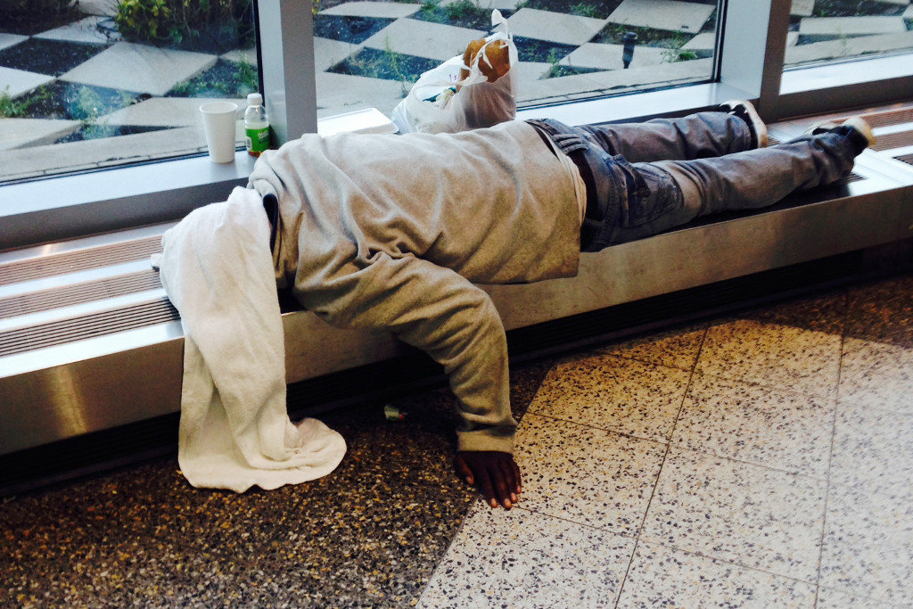 A  homeless man sleeps on a ledge at LaGuardia Airport