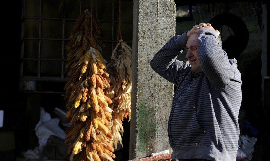 A man reacts after seeing his burnt house