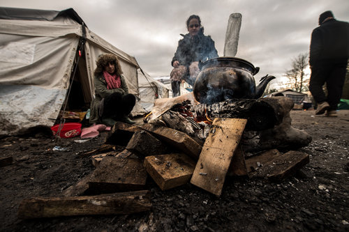 Click to enlarge Migrants get warm