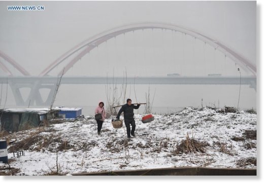 Click to enlarge Citizens walk on the snow-covered bank of the Xiangjiang River in Changsha, capital of central China's Hunan Province, Feb. 1, 2016