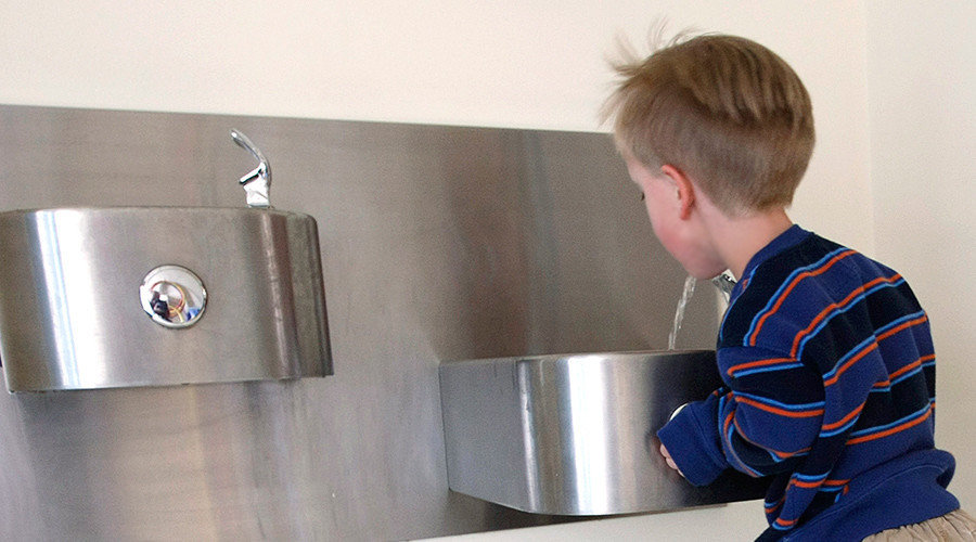 Boy drinking from a water fountain