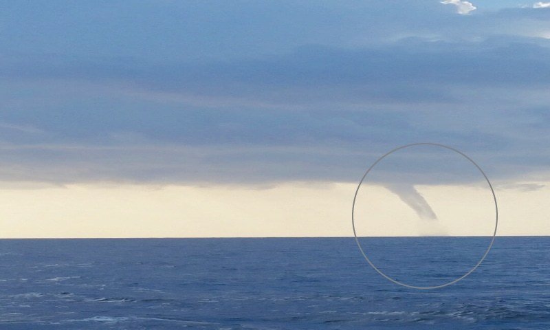 The funnel-shaped waterspout (in circle).
