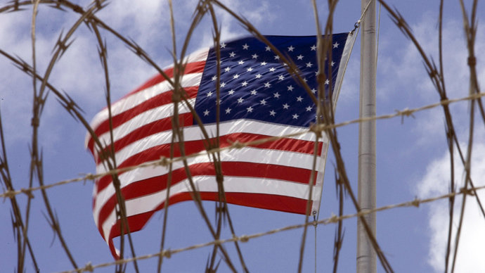 Click to enlarge American flag behind barbed wire