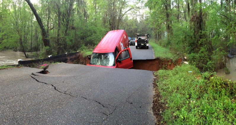 Click to enlarge A Coca-Cola truck gets swallowed up by a sink hole.
