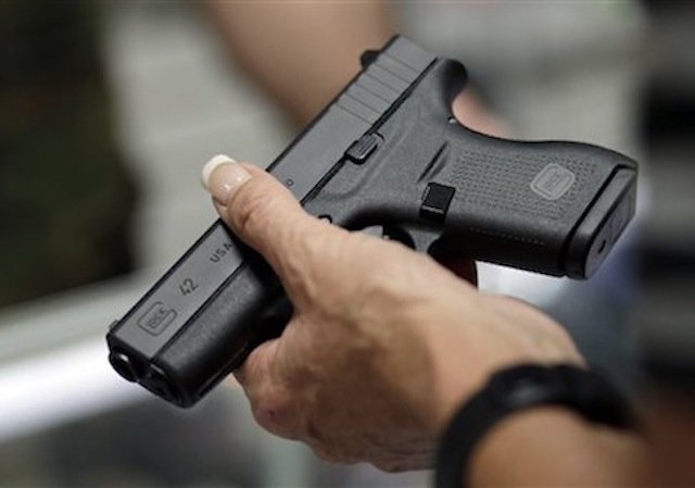Click to enlarge Woman holding gun