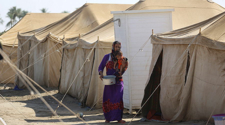 Click to enlarge An Iraqi displaced woman, who fled from Islamic State violence in Anbar, carries her child at a refugee camp near Amiriyat al-Fallujah