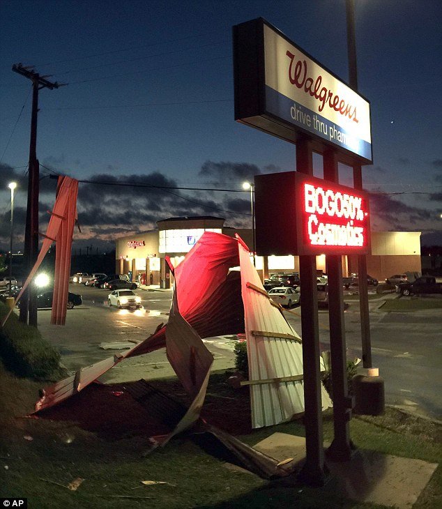 Twisted metal lies in the parking lot of a Walgreens in Wylie