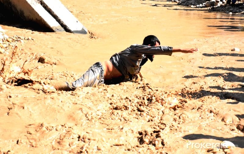 An Afghan man tries to get out of flood water after a heavy rain in Samangan province, northern Afghanistan, April 17, 2016.