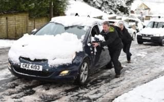  Two men push a car up a hill in Great Horton, Bradford, following heavy snow falls this morning.  