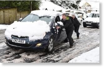  Two men push a car up a hill in Great Horton, Bradford, following heavy snow falls this morning.  