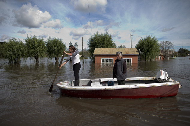 Two women row a boat on a flooded street of Villa Paranacito, Entre Rios, Argentina, Thursday, April 28, 2016. The Argentine Red Cross estimates that around 30,000 people have been affected after rains swelled rivers, swamping fields and towns nationwide.
