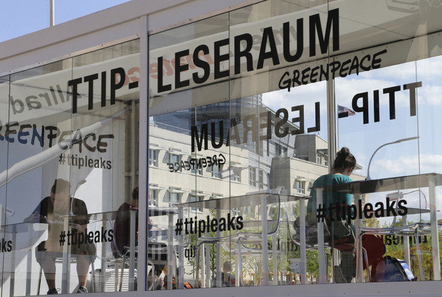 People read documents in a 'TTIP reading room' set up by Greenpeace in front of the Brandenburg Gate in Berlin, Germany.