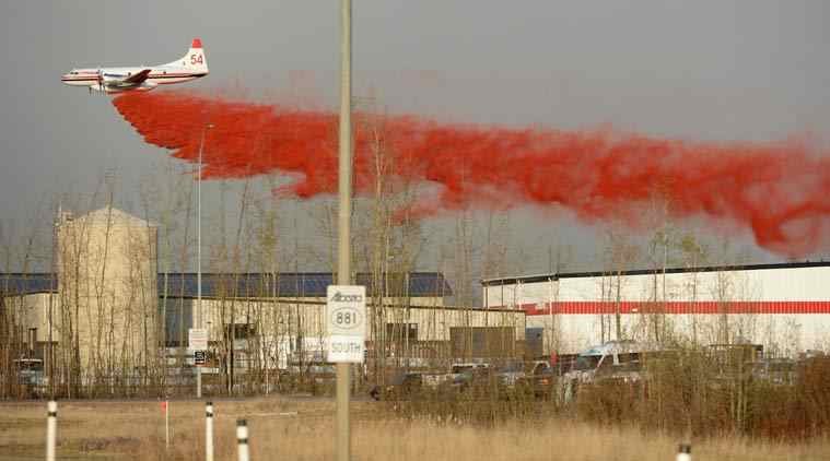 A plane drops fire retardant on a nearby wildfire in Fort McMurray, Alberta