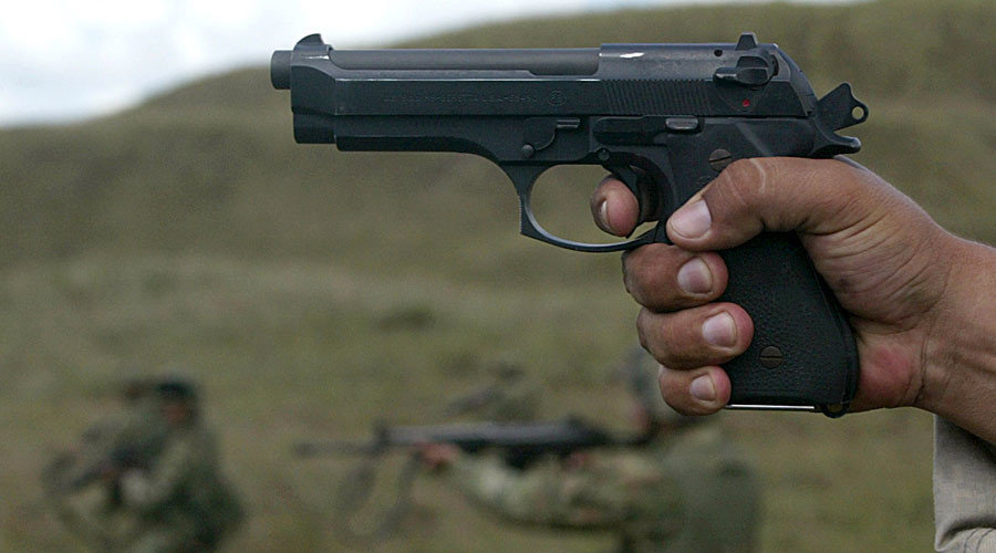 Dark skinned man holding a gun
