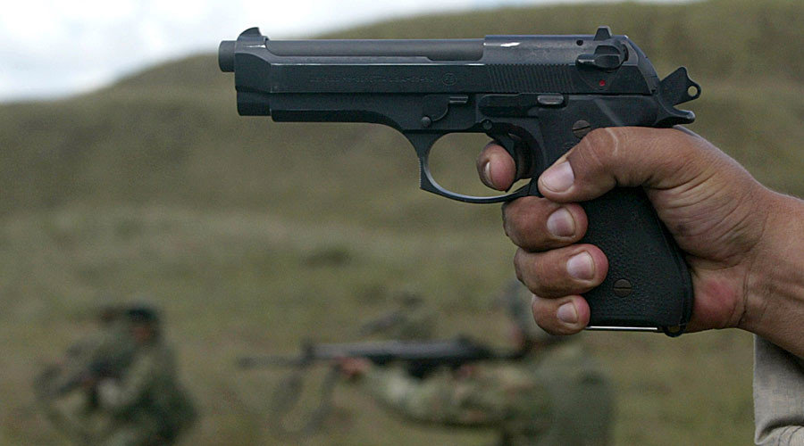 Click to enlarge Dark skinned man holding a gun