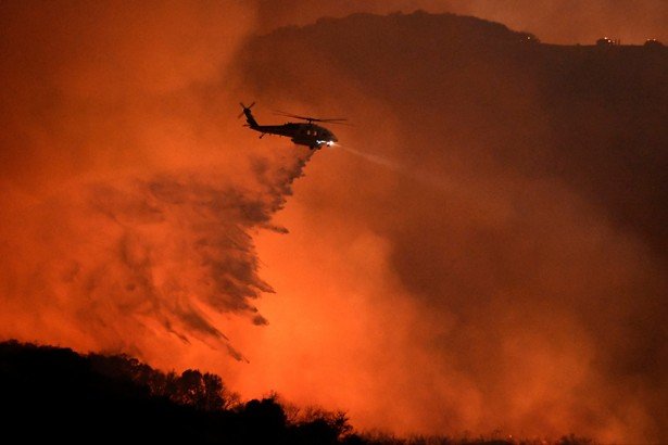  A helicopter makes a water drop on a fire in Calabasas, California.  