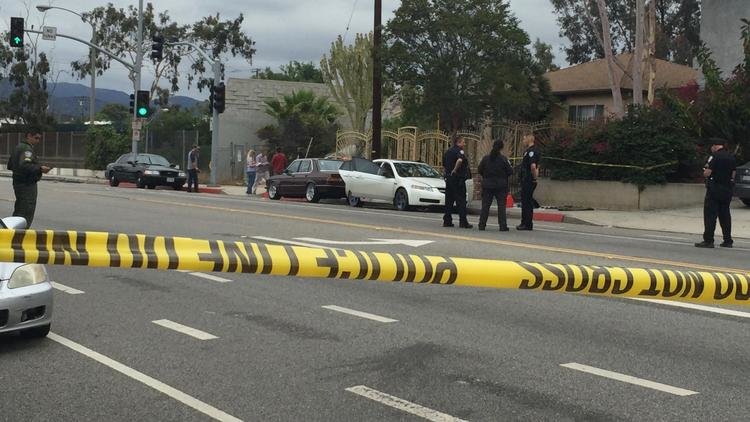 Police confer Sunday around a white Acura man arrested in Santa Monica.