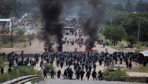 Policemen clashing with dissident teachers in Oaxaca, Mexico