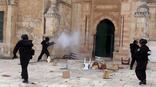 An Israeli soldier fires tear gas during skirmishes with Palestinian worshipers at al-Aqsa Mosque compound