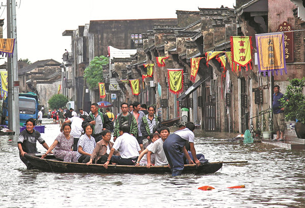 Click to enlarge Residents are moved to safety on Sunday in Tongling, Anhui province, as flooding continued to affect the city and other regions in central and eastern China.