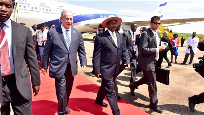 Israeli PM Benjamin Netanyahu (L) walks with Uganda's President Yoweri Museveni (R)