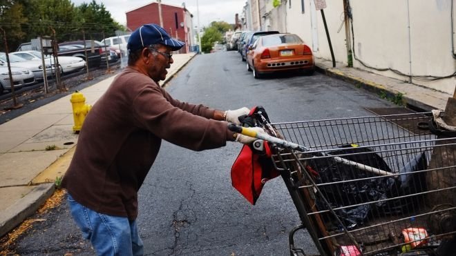 Homeless man pushing a cart
