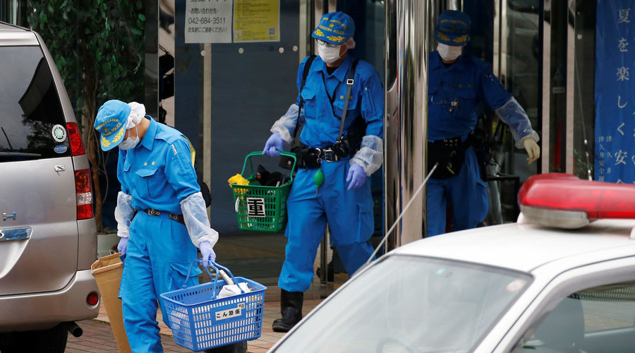 Police officers investigate at a facility where a deadly attack by a knife-wielding man