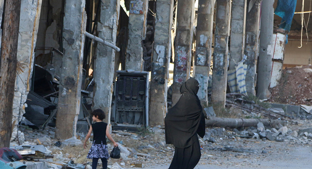 Woman walking past Aleppo destruction
