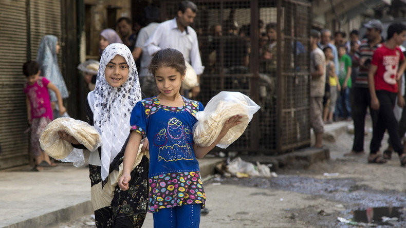 Syrian girls carry bags with bread in the northern city of Aleppo.